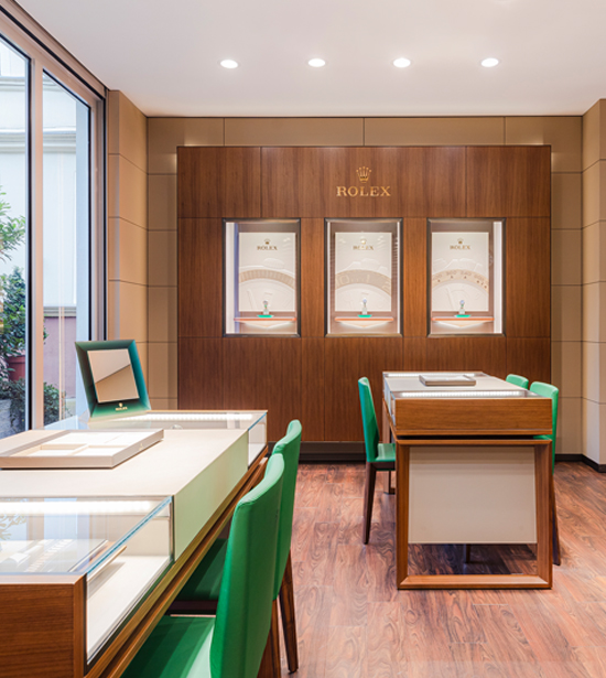 Rolex Showroom bei Juwelier Lorenz mit zwei Vitrinentischen und edlen Lederstühlen in grün